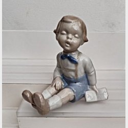 Vintage porcel�nsfigur - siddende dreng med en bog