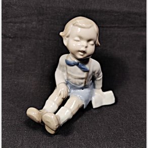 Vintage porcel�nsfigur - siddende dreng med en bog